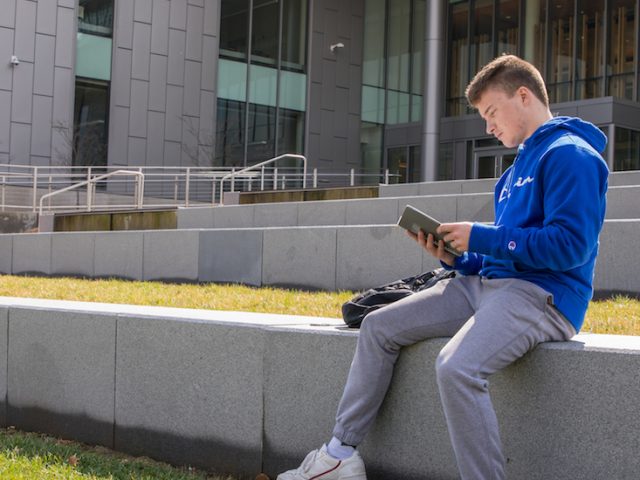 Tyler Weiss sits outside of Business Hall.