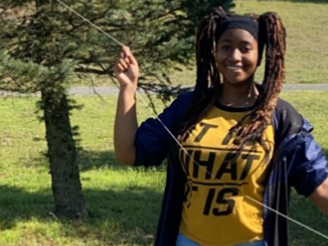 Photo of Maiyah outside in a yellow shirt and blue jacket