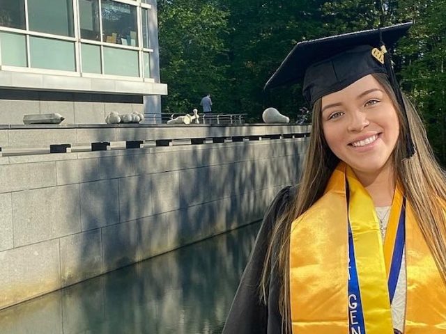 Ashley in her cap & gown near the Engineering Pond.