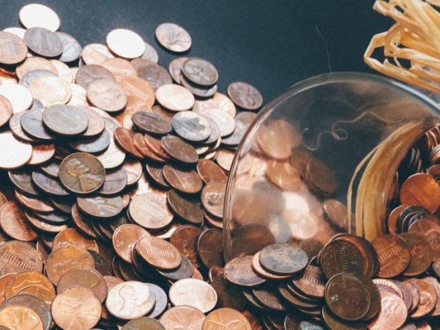 Stock image of pennies spilling out of a jar.