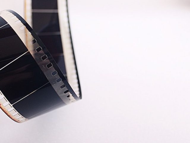 Stock photo of film unrolling against a white background.