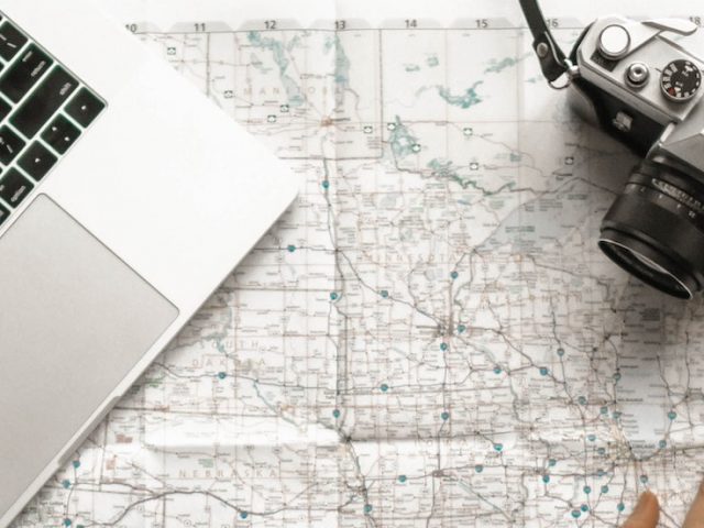 stock image of a laptop, map and a camera