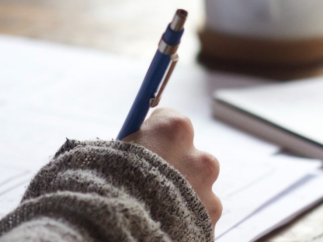 Stock image of a student writing in a notebook