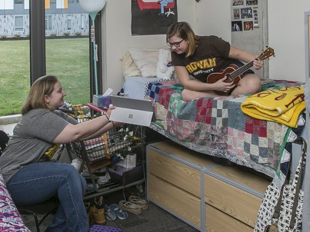 Two roommates hanging out in their dorm.