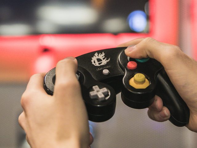 Student holds a gaming device in the Student Center Game Room.