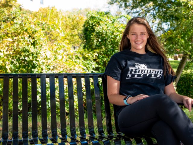 Catie sitting on a bench.