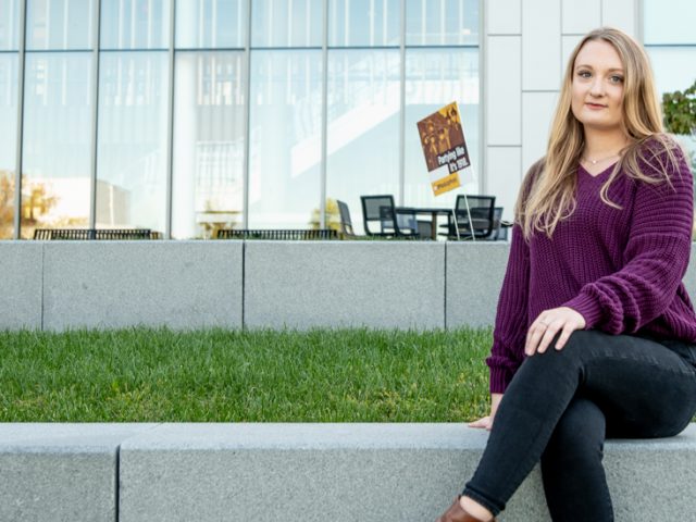 Exterior shot of Kailey Booth sitting on campus.