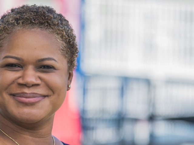 Erica Watson Brown stands outside of a playground.