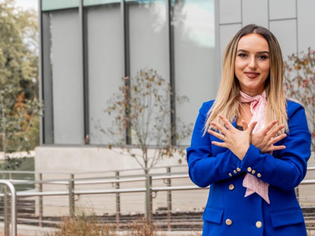 Elena photographed outside campus wearing a blue blazer.