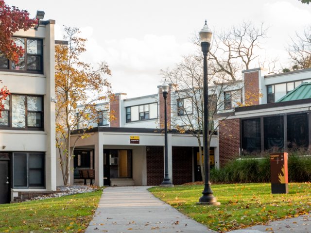 View of front door of Evergreen Hall, a one-story brick dorm.