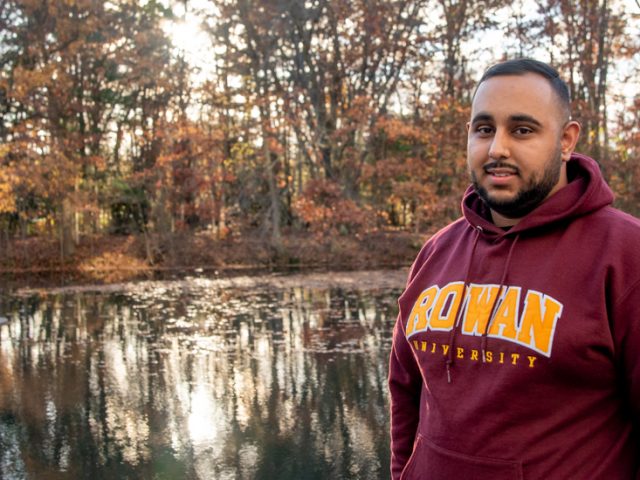 Muhammad standing in front of a pond.