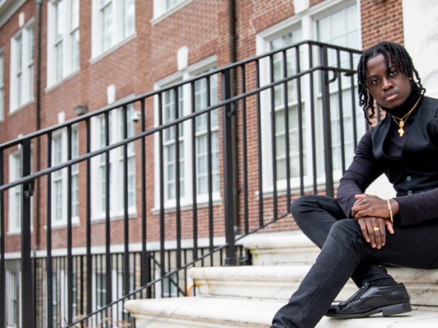 Poku sitting on steps outside of Bunce Hall.