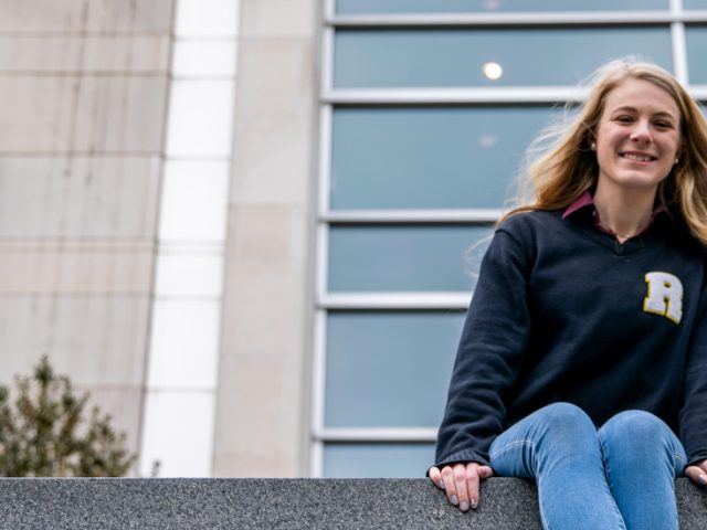 Ashleigh sits on a ledge outside of Engineering Hall.