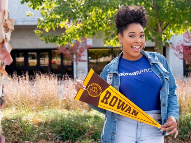 Cheyenne holds a pennant on campus.