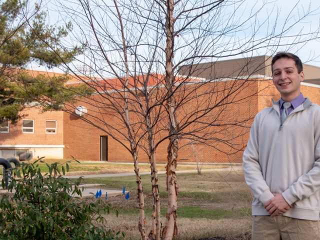 Steven poses outside by the Rec Center at Rowan.