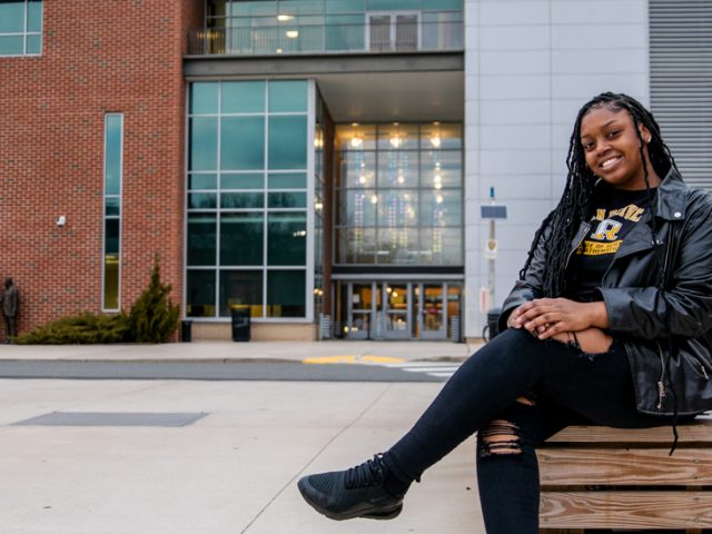 Ylanda sits outside campus near Campbell Library.