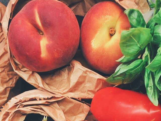 A stock image of peaches, basil and tomatoes.