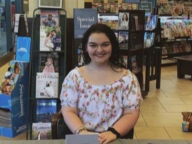 Jennifer sits at a table at a bookstore.