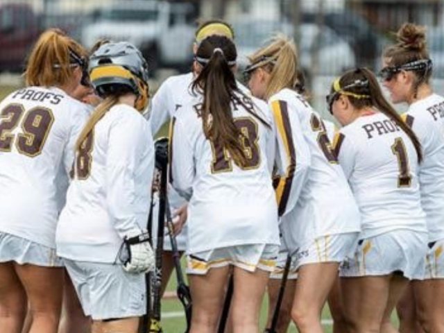 Rowan's Women's Lacrosse players huddle on the field.