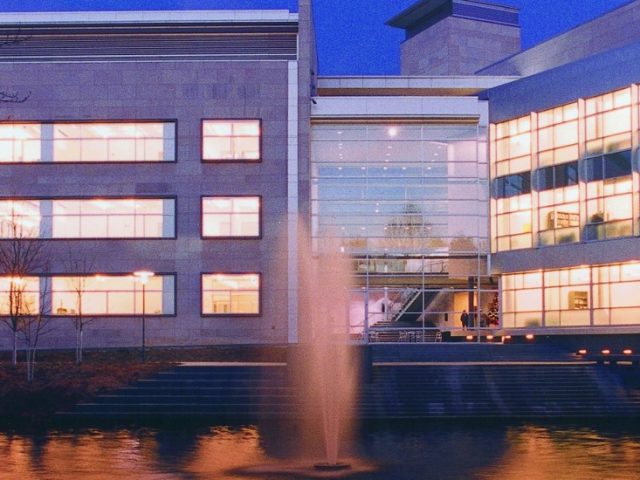 Rowan Hall in the College of Engineering at night, with fountains in the front.