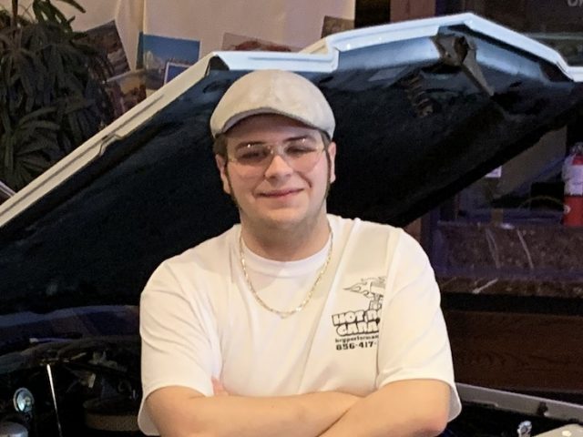 Richard wears a hat and stands next to a car in a supplied photo.