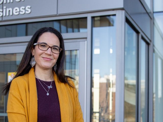 Dr. Susana Santos stands outside Business Hall.