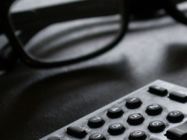 Stock image of eyeglasses and a remote control.