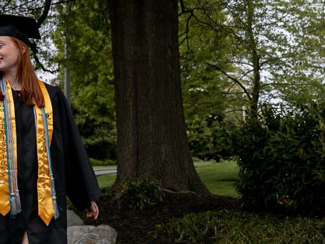 Ashley walks down Bunce Green in her cap and gown.