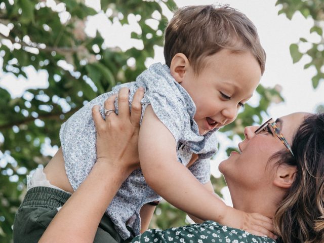 Alexis holds her son outside on campus.