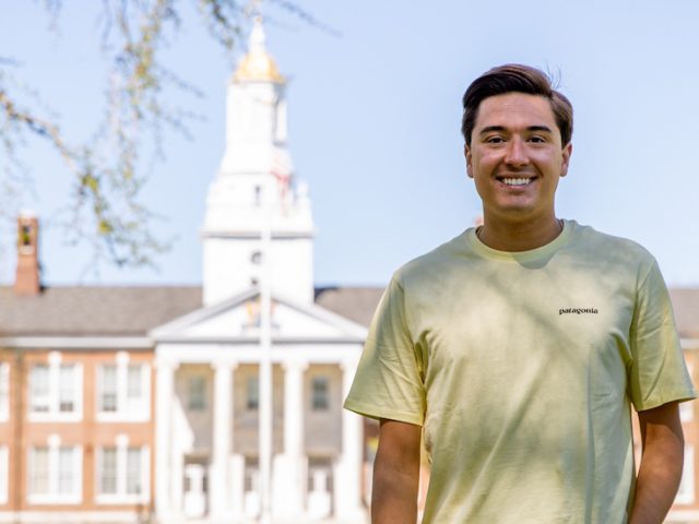 Anthony stands with Bunce Hall far in the distance.