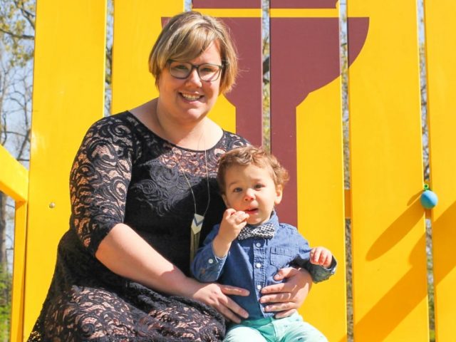 Cory sits with her son on the Rowan Proud chair.