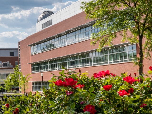 Photo of Science Hall and flowers in the foreground.