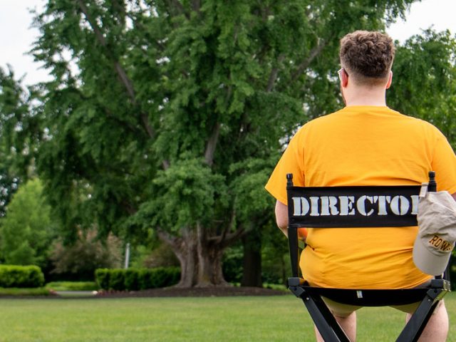 Nick sits in a director's chair on Bunce Green.