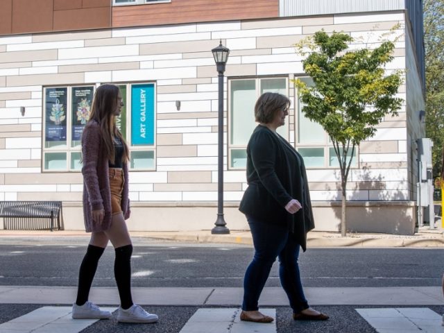 Lisa Fagan and her students walk in the crosswalk in Abbey Road fashion.