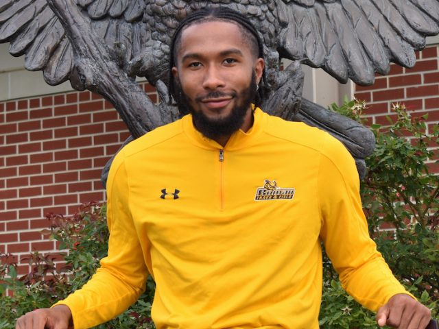 Jah'Mere sits in front of the Rowan Athletics Owl statue.