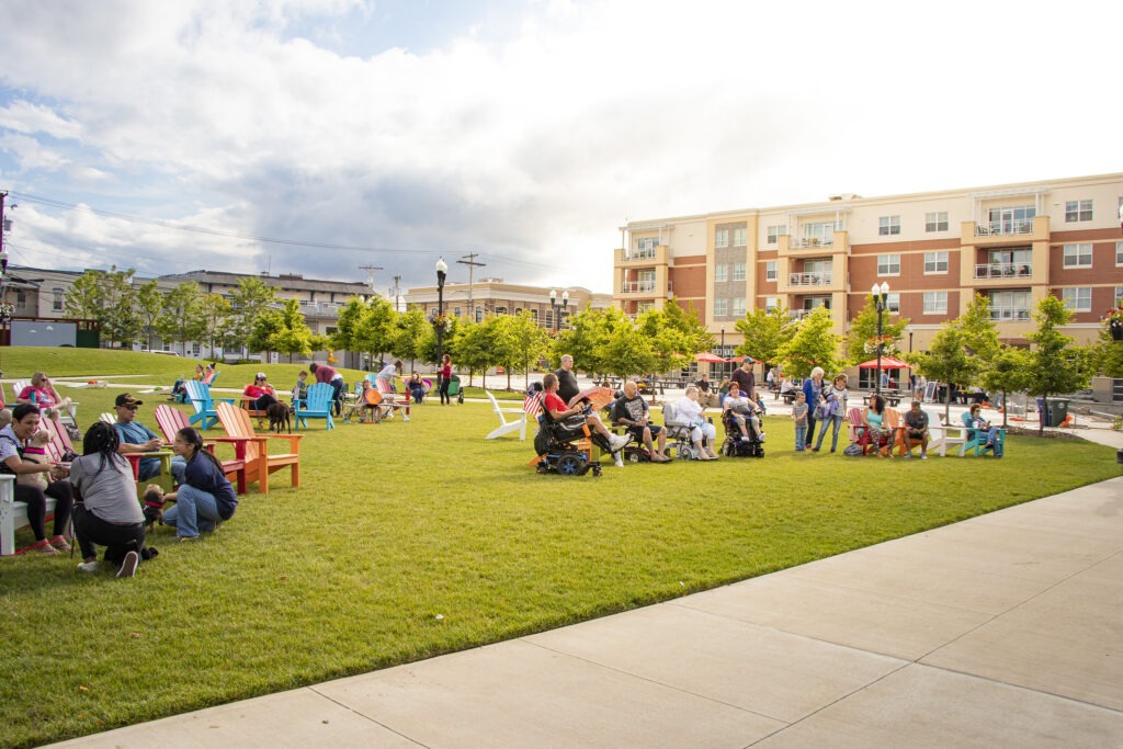 Four groupings of chairs are spaced apart in a grassy park area of Towne Square, at Rowan Boulevard.
