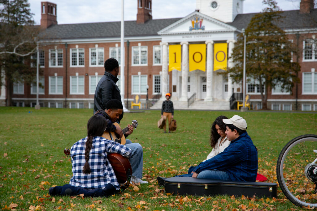 Bunce Hall, four students sitting in the grass relaxing and socializing