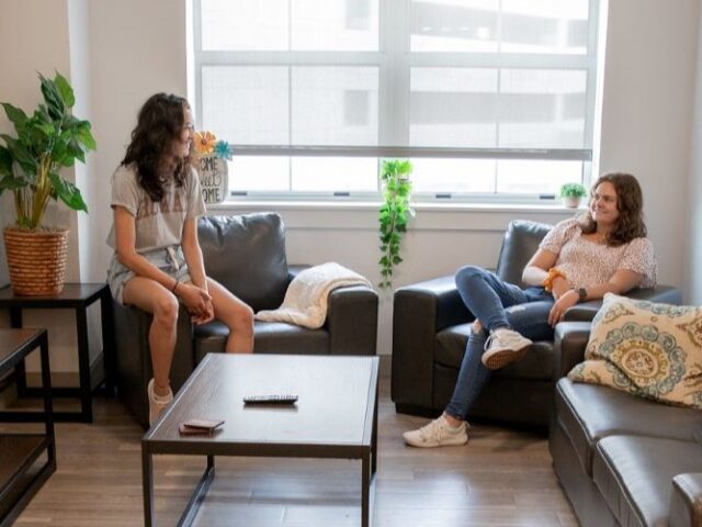 2 Rowan Students talking inside an apartment