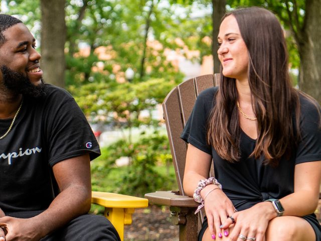 Natalie sits with her coworker Reshaun on campus.