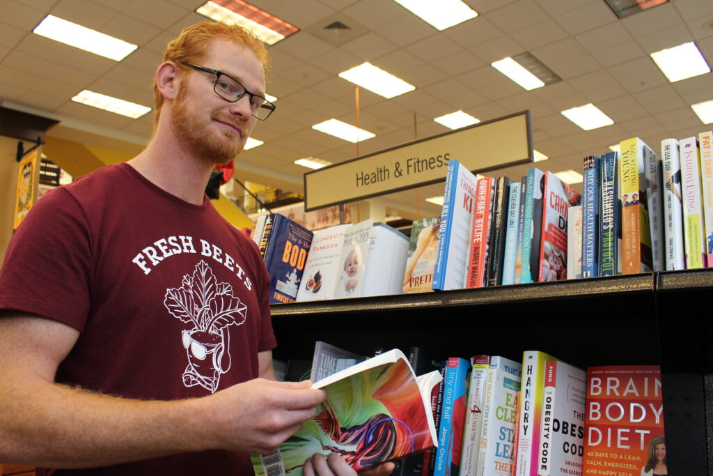 A student flips through a book in the Health & Fitness section of Barnes & Noble at Rowan University.