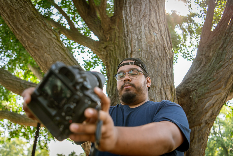 Alex takes a selfie with his DSLR camera.