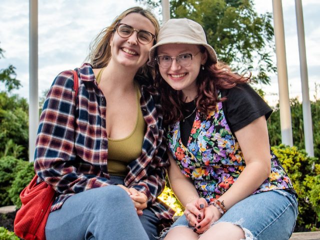 Olivia and Liz sit outside Holly Pointe Commons.