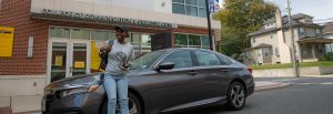 Nene leans against her car outside of the Victoria building.