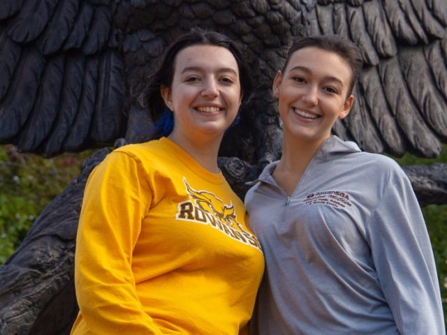 Sarah and Madeline pose together in front of the owl statue.