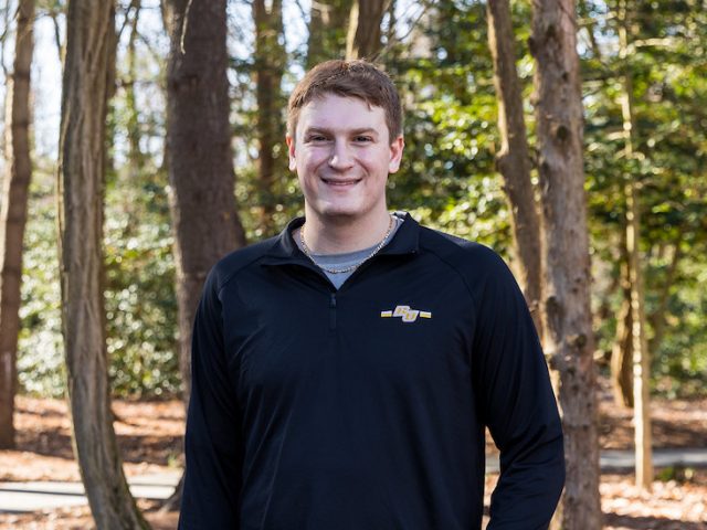 Matthew Beck smiles and stands outside near the College of Engineering academic buildings on campus.