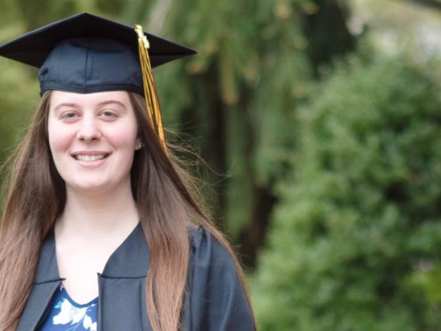 Liliana wears her graduation cap and gown.