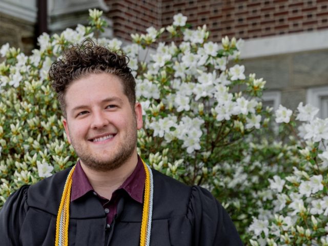 Nick poses in front of some flowers