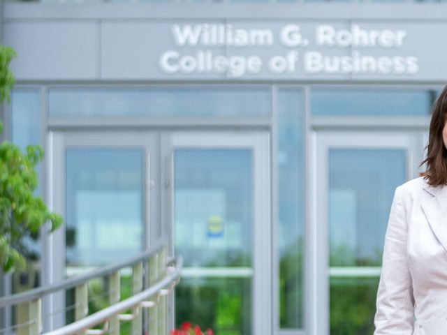 Annabella is standing in front of the Rohrer College of Business.