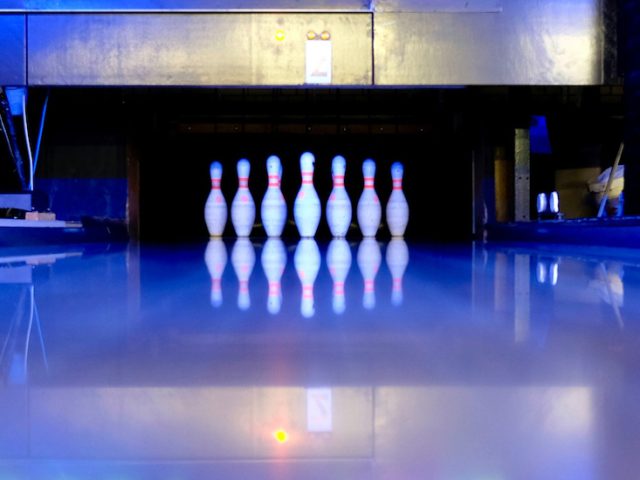 Stock image of the interior of a bowling alley with stacked pins.