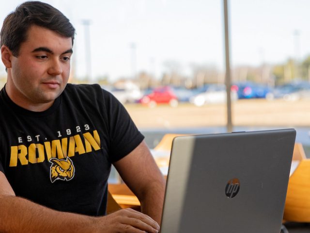 Mechanical Engineering major Carmine works on his laptop inside Engineering Hall.